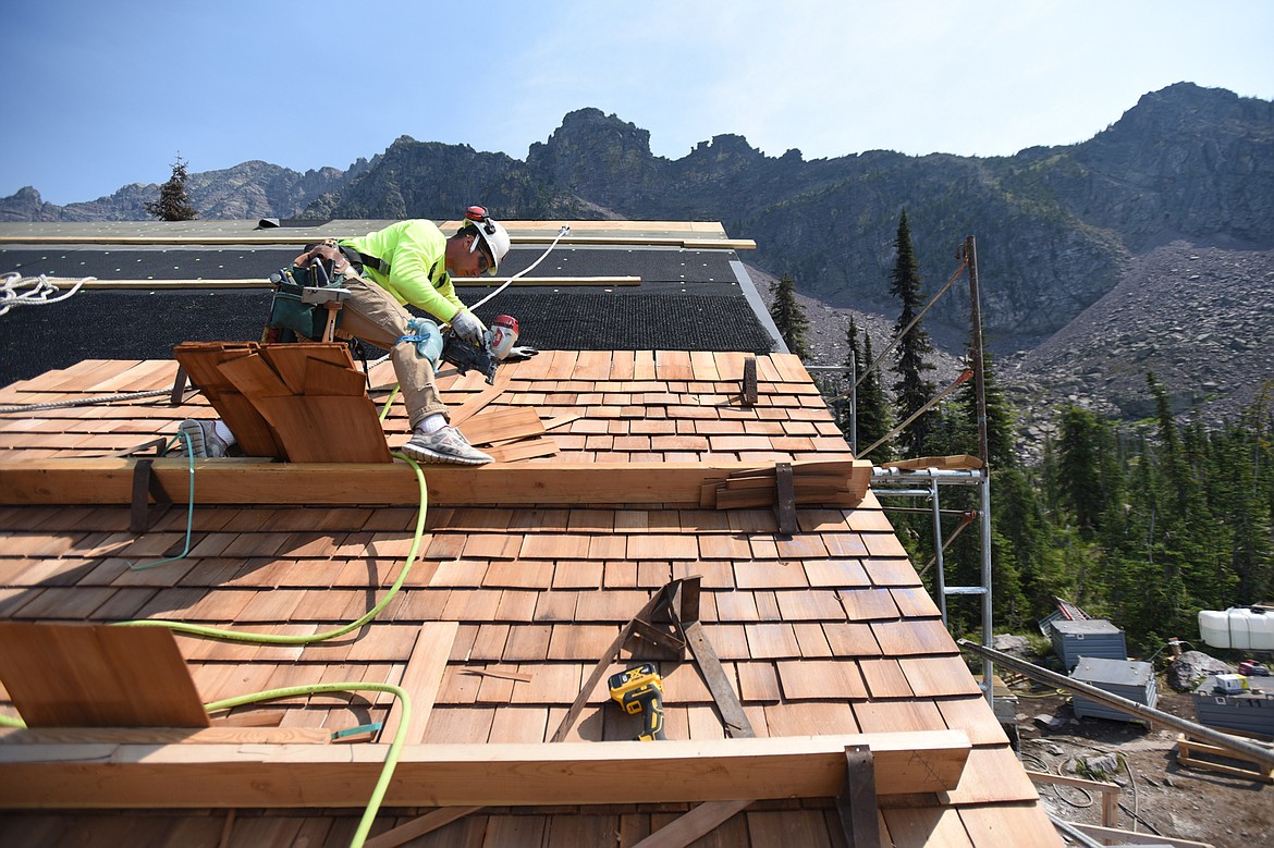 Nick DeLude, with Dick Anderson Construction, installs cedar shake shingles to the Sperry Chalet roof in Glacier National Park on Thursday, Aug. 8. (Casey Kreider/Daily Inter Lake)