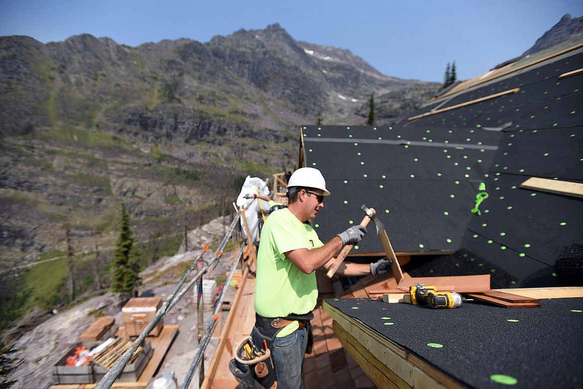 Rafe Friede, with Dick Anderson Construction, installs cedar shake shingles on the roof of Sperry Chalet in Glacier National Park on Thursday, Aug. 8. (Casey Kreider/Daily Inter Lake)