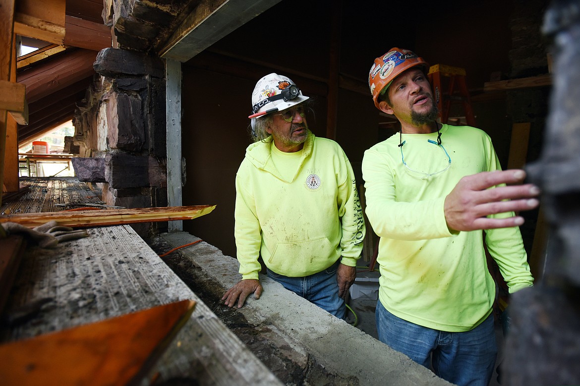 Alex Gladstone and Jeremy Hilton discuss methods of removing lingering carbon from the stonework caused by the Sprague fire inside Sperry Chalet in Glacier National Park on Thursday, Aug. 8. (Casey Kreider/Daily Inter Lake)