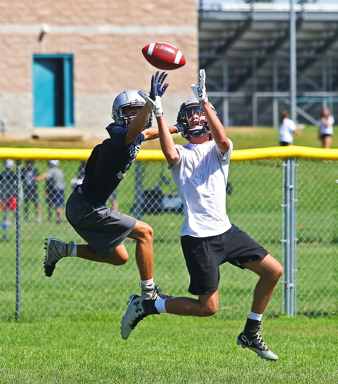 Junior Cody Gervais and senior Lukas Neal both jump to catch a pass during practice Tuesday at Lake City High School.