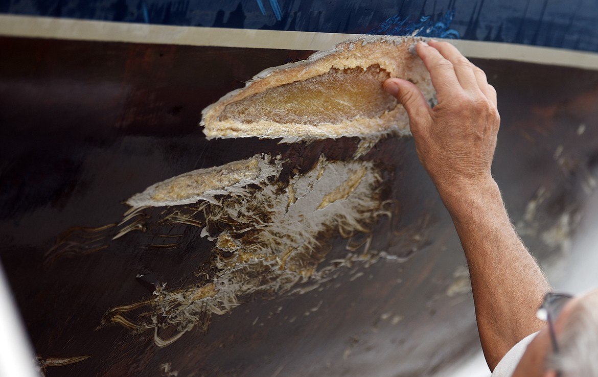 Dick Graf takes a closer look at the damage to his boat, the Gayle Force.