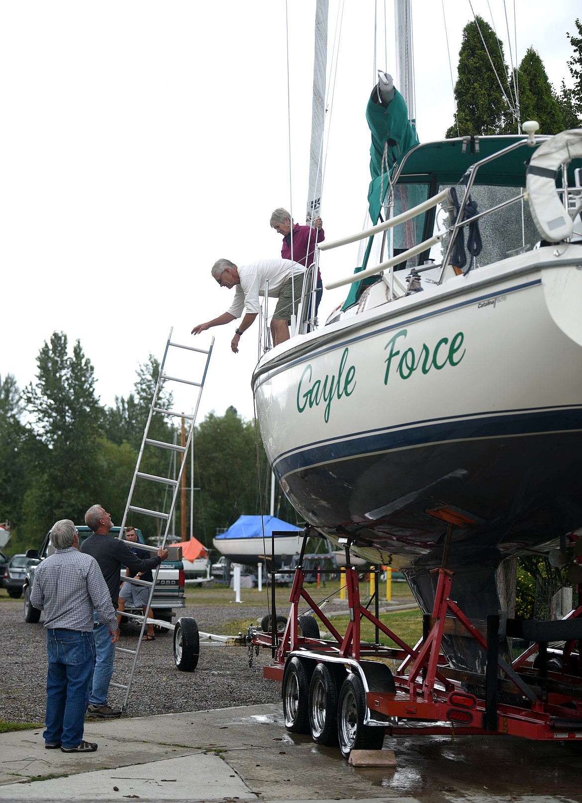 Dick and Gayle Graf climb down from their boat the Gayle Force which they took out of the water to access the damage received in the storm over the weekend.(Brenda Ahearn/Daily Inter Lake)