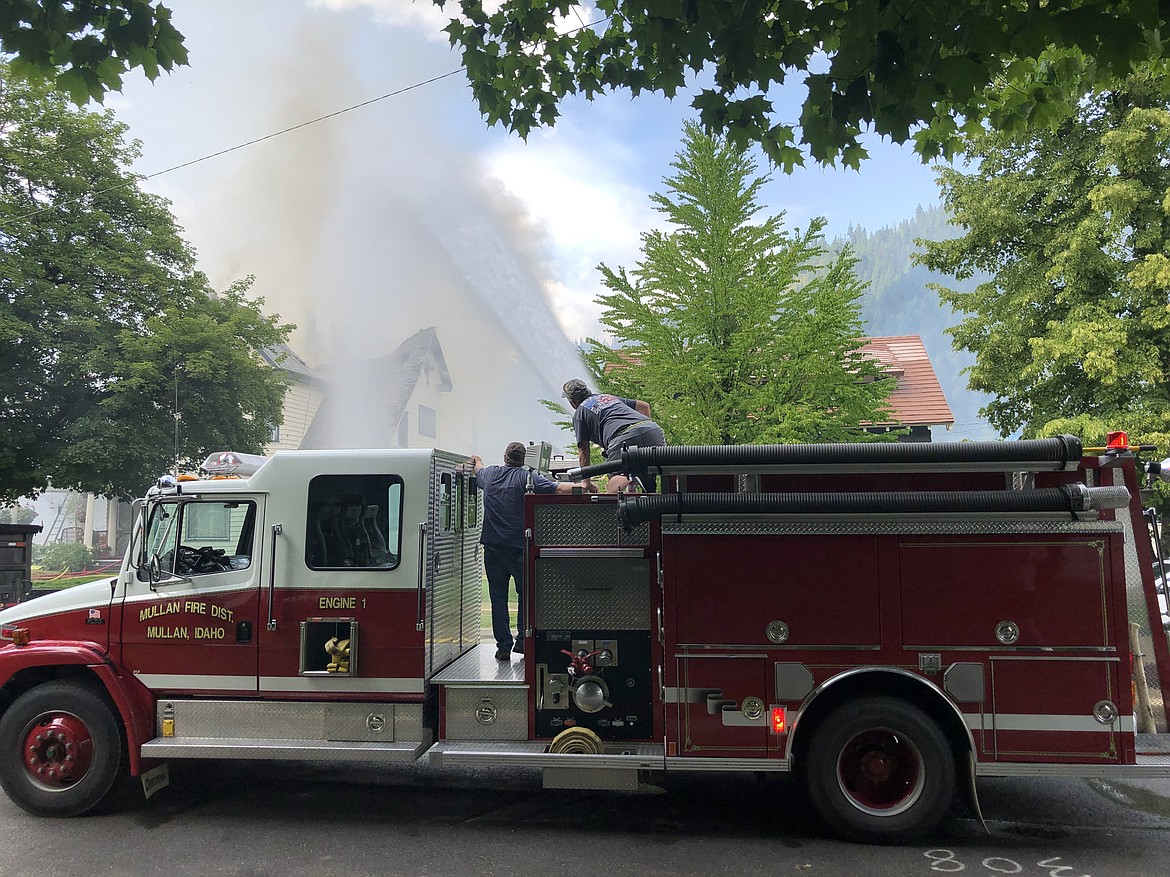 Photo by JOSH MCDONALD/
Mullan Fire Department crews use a mounted water cannon from their engine to keep a steady stream of water on the rooftop.