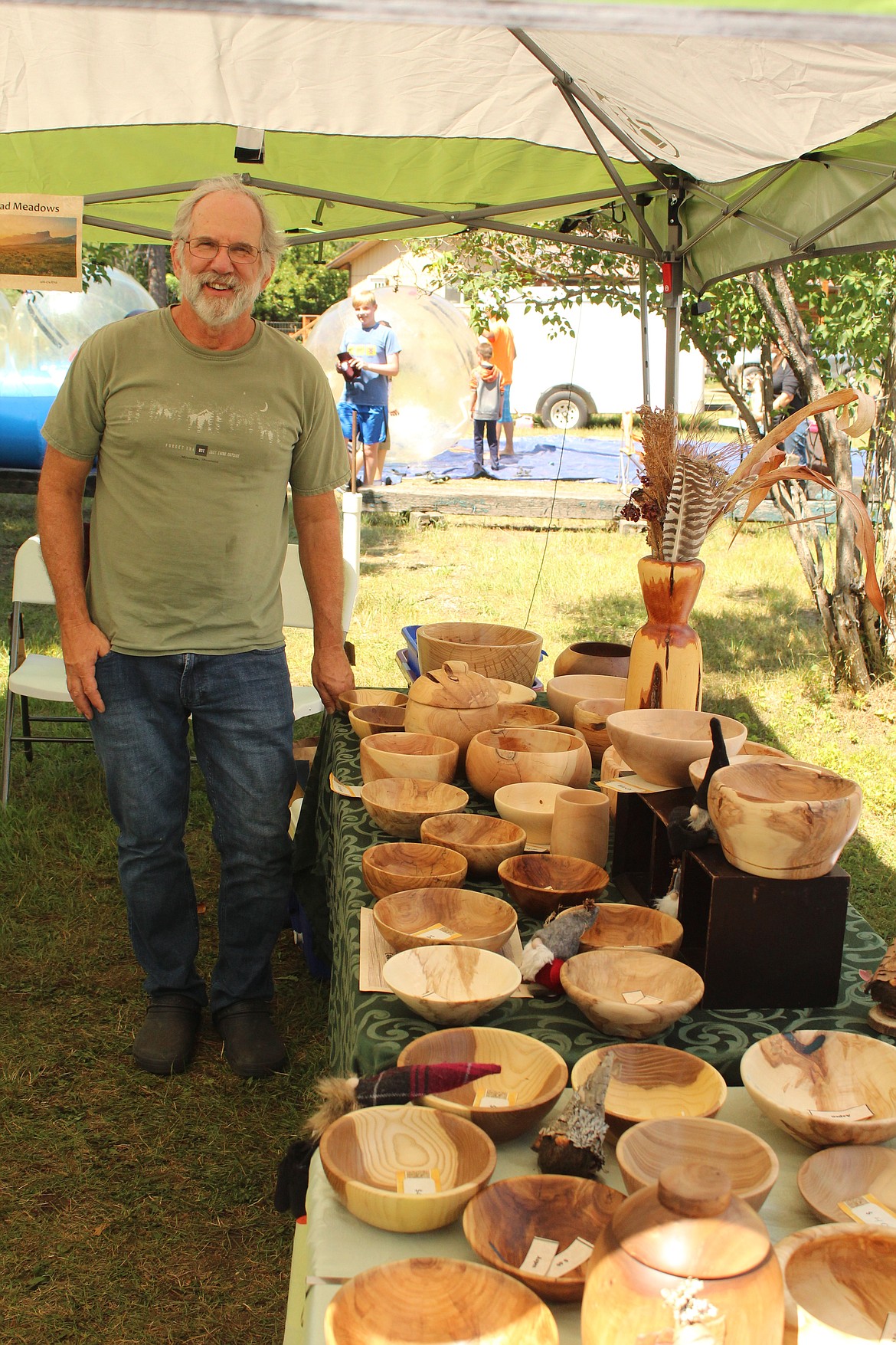 BRAD STACEY displaying his handmade wooden bowls at the Huckleberry festival in Trout Creek. (John Dowd/Clark Fork Valley Press)