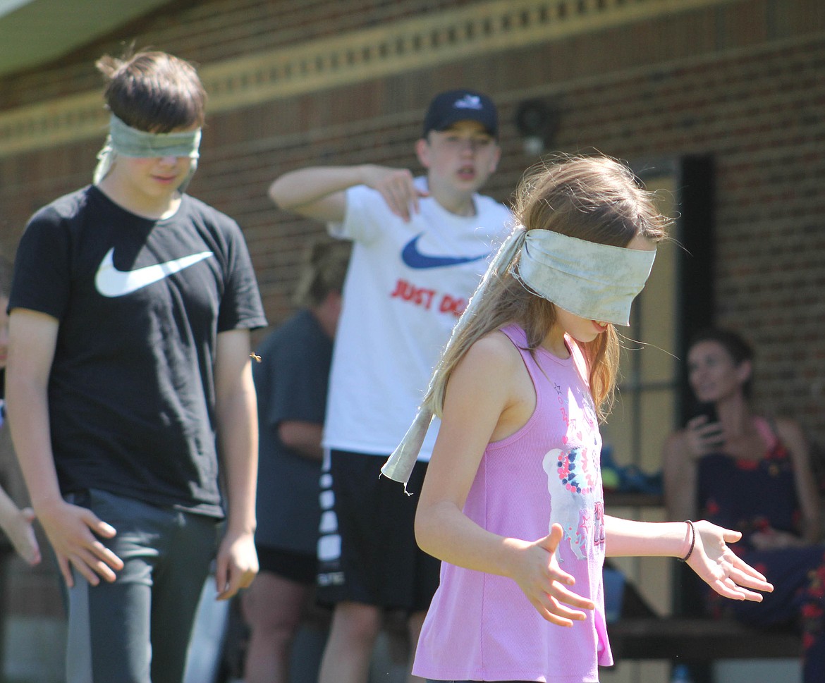 Tenth-grader Carter Jasper instructs his blind-folded partner, sixth-grader Lilly Sansom, in a communication activity in St. Regis on Tuesday, August 6. The exercise was affiliated with the Mineral County Health Department, Western Montana Mental Health Center and Parenting Montana. Missoula Parks and Recreation brought the activities. (Maggie Dresser/Mineral Independent)