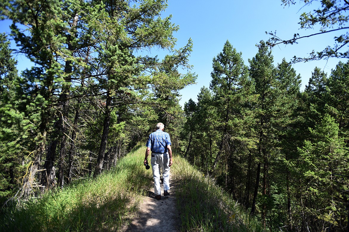 James Korn, sexton at C.E. Conrad Memorial Cemetery, walks along a grassy promontory leading to the &#147;fairy steps&#148; and the Stillwater River in Kalispell on Thursday, Aug. 1. (Casey Kreider/Daily Inter Lake)