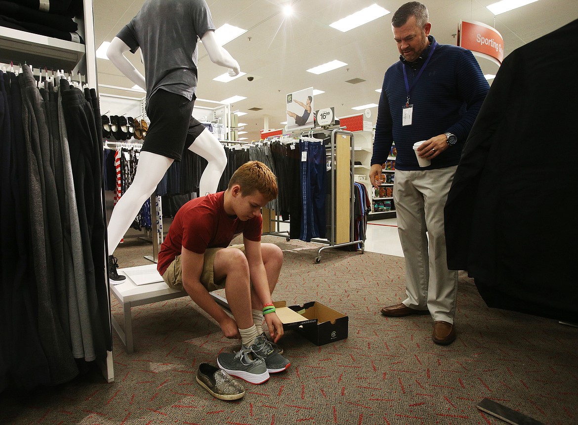 Kobi Jones, 16, tries on new shoes with Boys and Girls Club executive director Ryan Davis during the Back-to-School Blessings event Tuesday morning. A dozen underprivileged youths were treated to a shopping session with local community leaders including Davis, Coeur d'Alene Mayor Steve Widmyer, Post Falls Mayor Ron Jacobson and others. (LOREN BENOIT/Press)