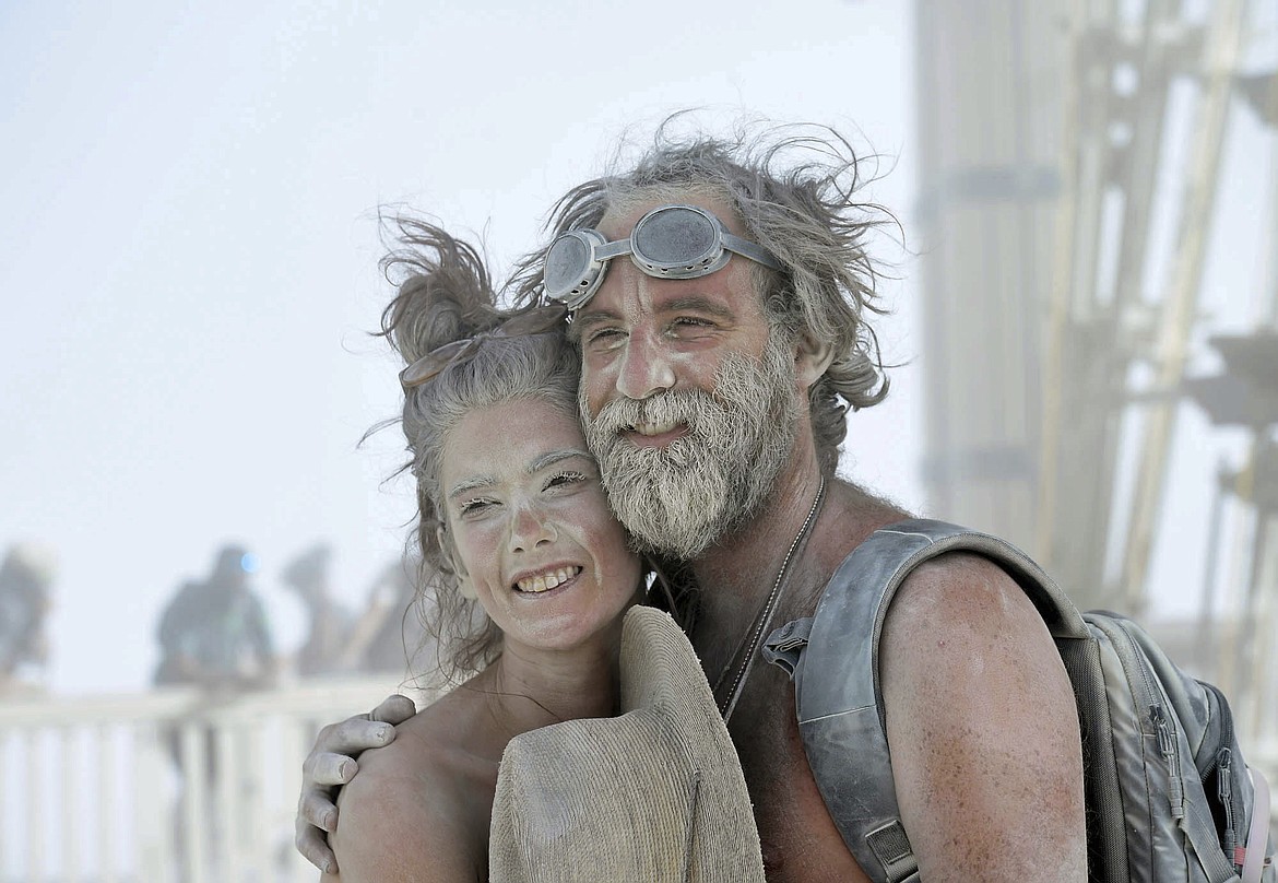 In this Aug. 30, 2017, photo, Mairi Clairebowser, of Scotland, left, and Ben Madden, of California, pose for a friend with their faces covered in dust at Burning Man in Gerlach, Nev. Breakfast, lunch and dinner at Burning Man is served with a side of playa dust that covers cars and clothing and finds its way into places where the sun doesn&#146;t shine. (Andy Barron/The Reno Gazette-Journal via AP)