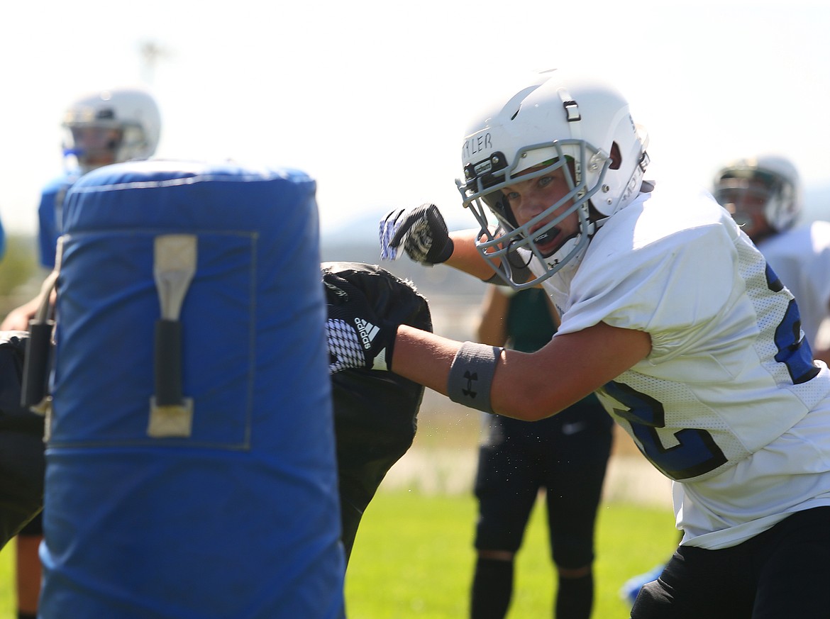 Tyler Konrad, an eighth-grade student at Canfield Middle School, swims by a makeshift block for a tackle during Coeur d&#146;Alene High School&#146;s Junior Tackle camp.