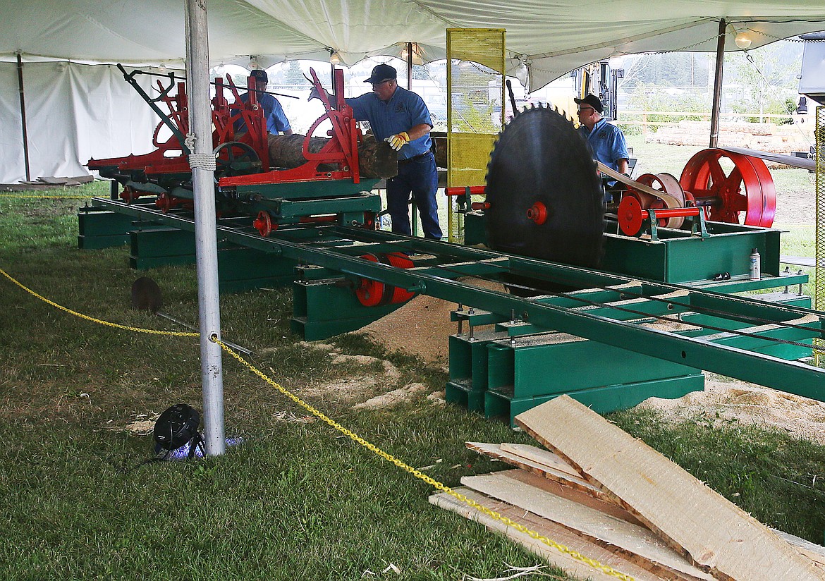 Men from the Idaho Forest Group feed a fresh log into the a 1909 Frick sawmill during a demonstration Friday at the North Idaho State Fair. (LOREN BENOIT/Press)