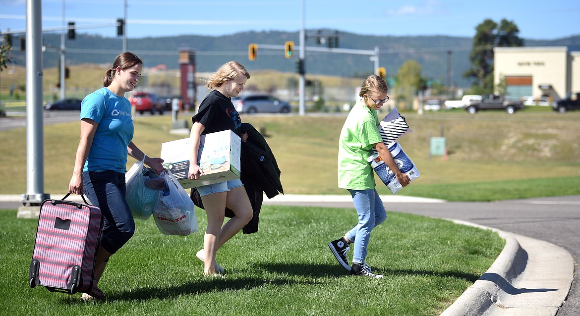 Student Stacey Hamilton of Lakeside, center, gets help moving boxes into her dorm room from her sister Abbigail, right and volunteer Katie McFate on Monday morning, August 26, at Flathead Valley Community College.(Brenda Ahearn/Daily Inter Lake)