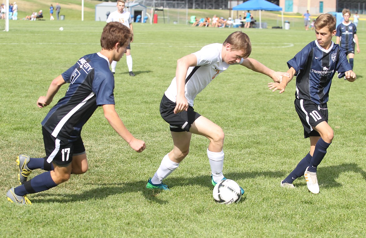 JASON ELLIOTT/Press
Post Falls senior Carson Jacobsen splits the defense of Lake City&#146;s Kohrt Weber, left, and Landon Lee, right, during Wednesday&#146;s YEA Jamboree at the Irma Anderl Soccer Complex.