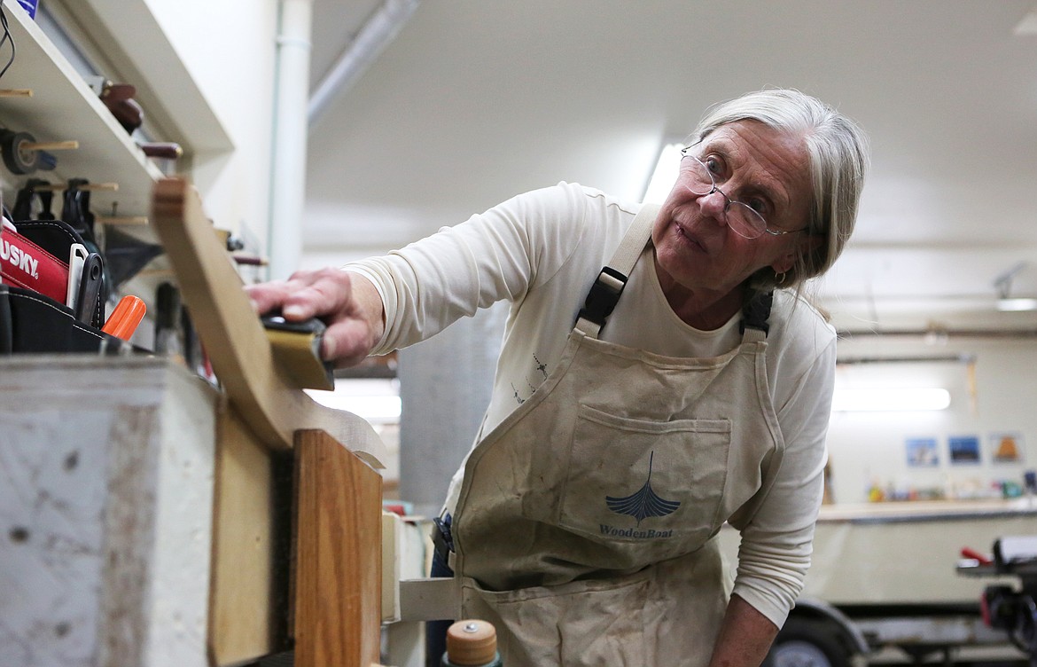 Susan Timmons sands the tiller of her sailboat during the Montana Wooden Boat Foundation boat building class on Tuesday, Aug. 20. (Mackenzie Reiss/Daily Inter Lake)