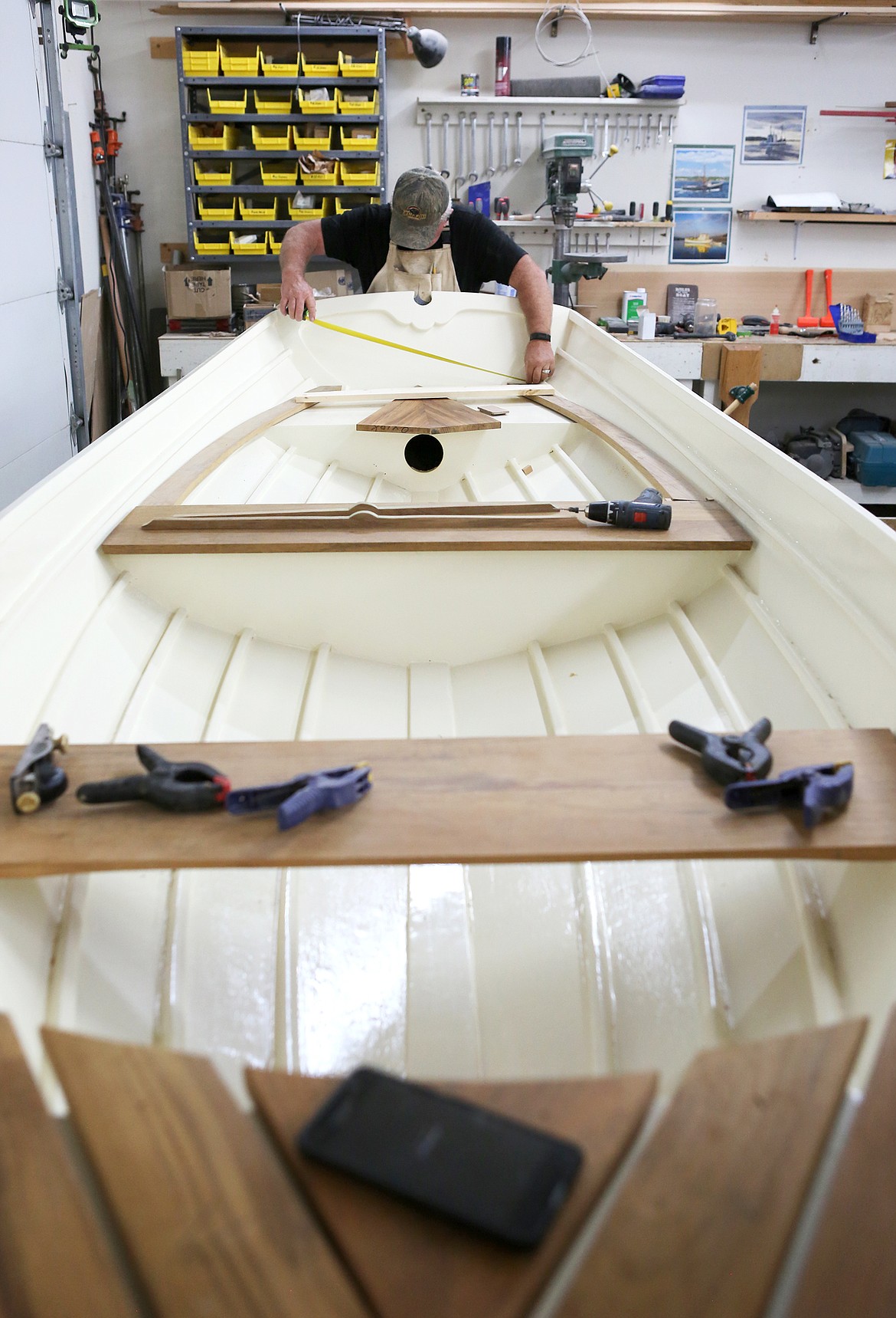 Frank Charboneau, of Bigfork, measures the transom of his Penobscot 14 during the Montana Wooden Boat Foundation boat building class in Lakeside. (Mackenzie Reiss/Daily Inter Lake)