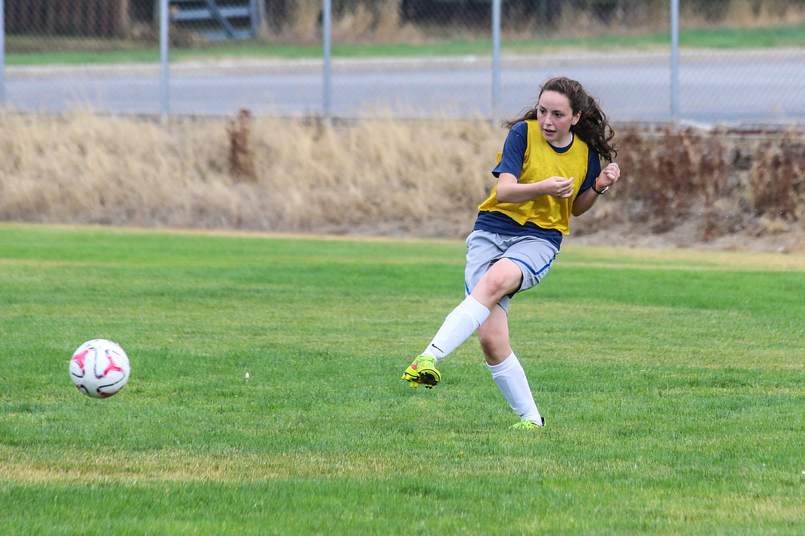 Morgan Swanson, left, and Sophia Roemer kick the ball during practice.