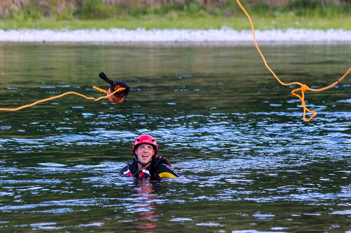 Photos by MANDI BATEMAN
Throw bags in flight from North Bench Firefighters reach Boundary Search and Dive Rescue Commander Tony Jeppesen, who played the part of the victim, during an Aug. 22 rescue training exercise.
At left, North Bench Firefighter Colin Mangus practices with a throw bag.