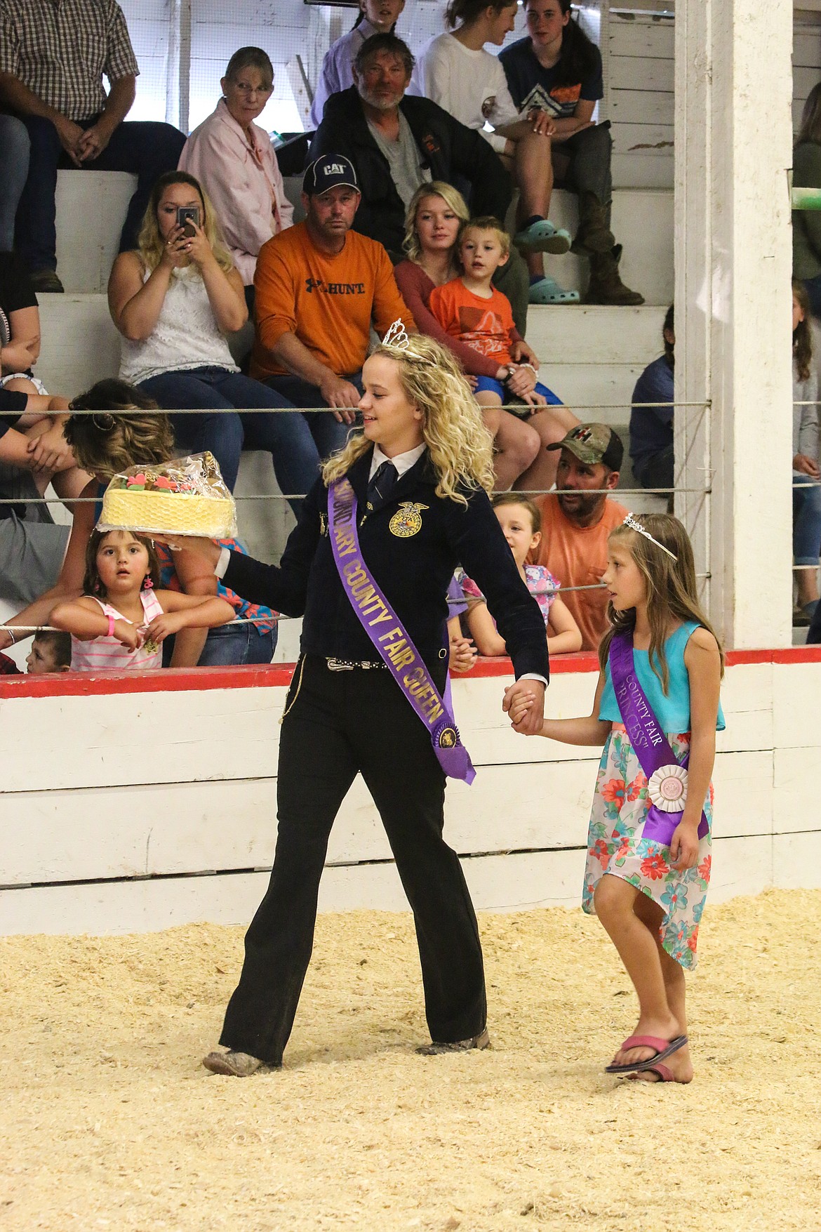 Princess Sydnee Blevins showcases a cake during the bake sale that was won twice, finding its home with Caleb Davis.