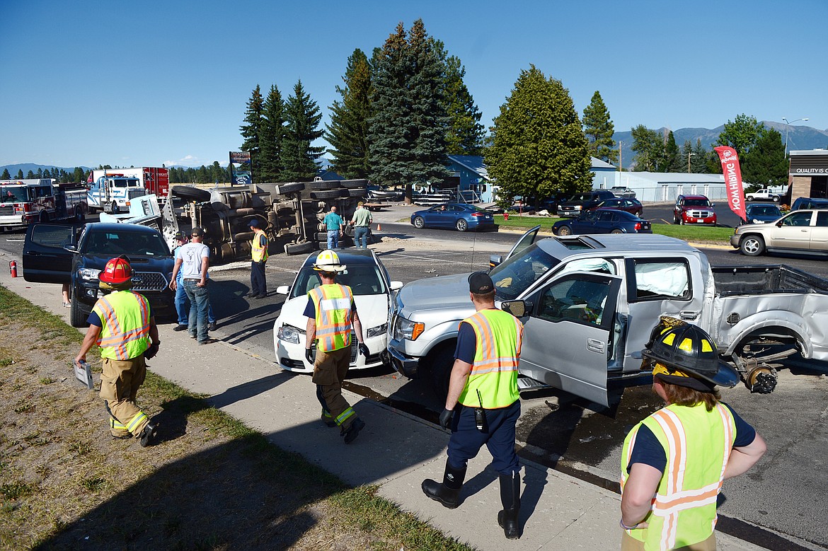 Emergency responders at the scene of a four-vehicle crash that caused a dump truck to spill a load of stone along U.S. Highway 2 at Reserve Drive in Evergreen on Tuesday, Aug. 20. (Casey Kreider/Daily Inter Lake)