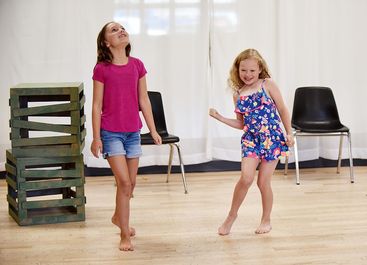 Top, during rehearsal of their scene, Ella Gripton, right, celebrates beating Hannah Szady in a game of rock-paper-scissors during the Whitefish Theatre Co. summer performance camp. Left, Bronwen Prew pretends to cry while holding her script during a practice session. The young actors learned how to collaboratively build a play from the ground up. They created a story and script for their play, rehearsed, and eventually designed scenery, props and costumes to bring the play to life.