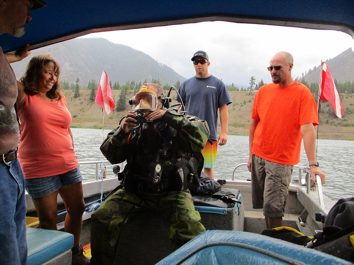 MEMBERS MASON and Tricia Cottrell along with Sheriff Tom Rummell help 
rescue diver Bob Thornhill prep for a locating and recovery dive of Sidney the rescue dummy. (Photo credit Shelly Rummell/ Clark Fork Valley Press)