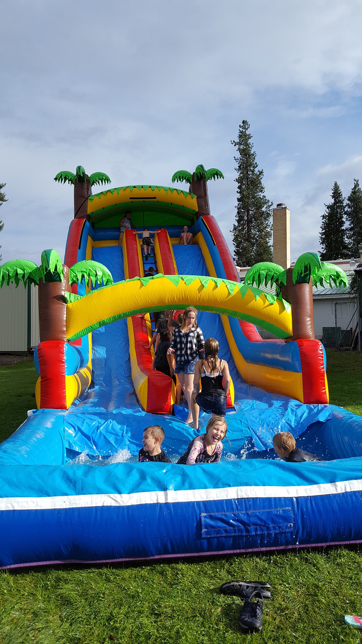 Children make a splash in one of the water slides set up by Jump for Joy, out of St. Ignatius, for the back-to-school bash. The two slides and the water tank were a big hit with the younger children, while older children played on the basketball court, football field or danced to the music. Cotton candy was also available to the children.