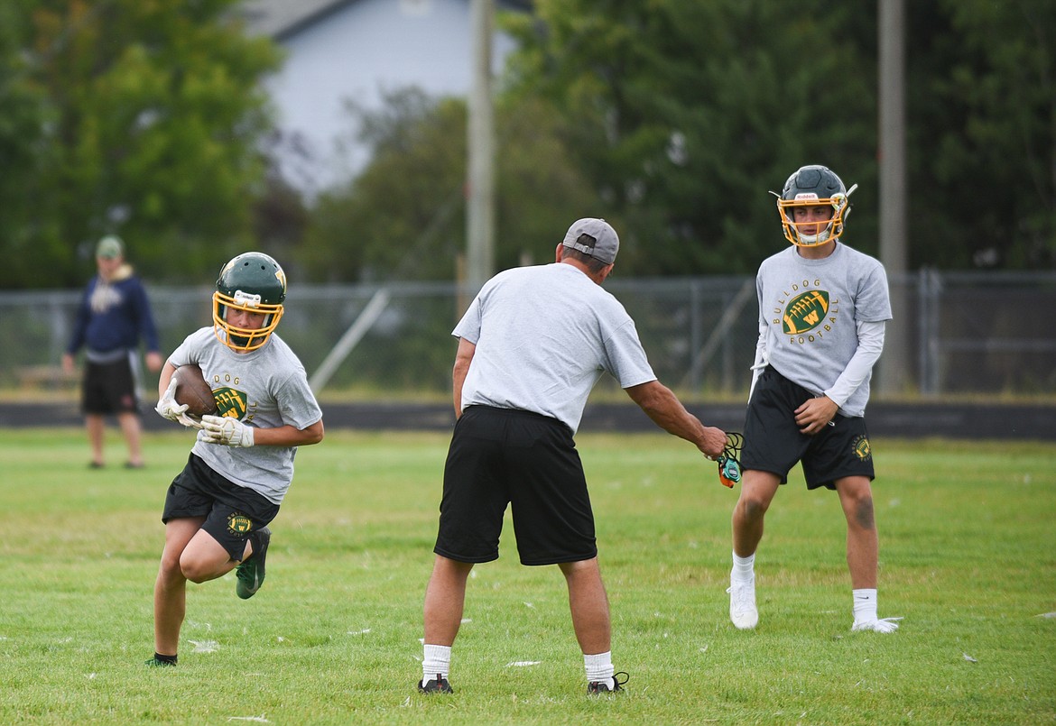 A pair of Bulldogs practice a handoff last Friday.  (Daniel McKay/Whitefish Pilot)