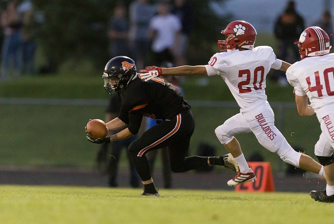 JASON DUCHOW/Jason Duchow Photography
Tommy Hauser of Post Falls snags a low pass against Sandpoint as Bulldogs Walker Herrman (20) and Elek Christoferson (40) defend Friday night in Post Falls.