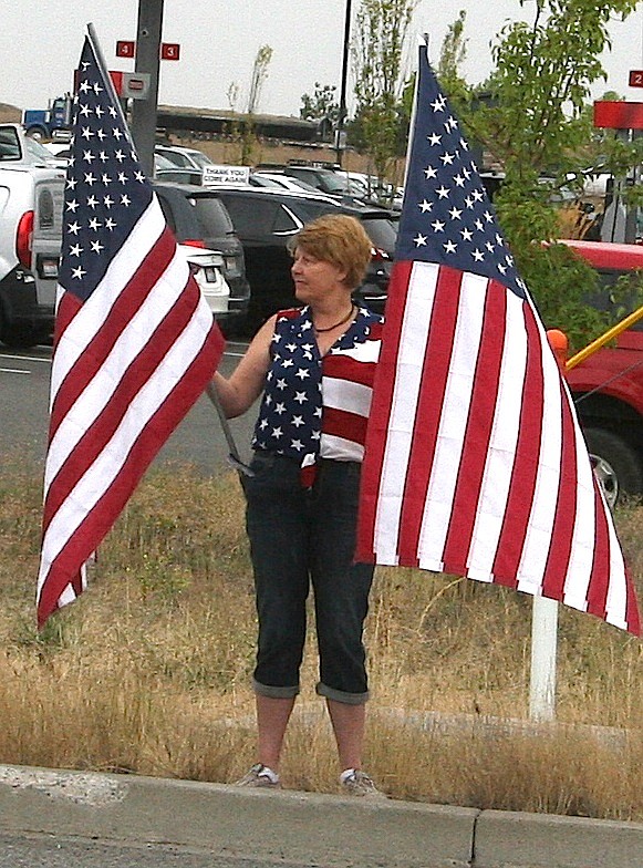 Coeur d'Alene's Susan Manthey shows her support on Friday for Army Sgt. First Class Brian Sharp, who was injured during a gun battle in Afghanistan. Thousands of citizens lined U.S. 95 to welcome the soldier from Montana with North Idaho ties back. (BRIAN WALKER/Press)