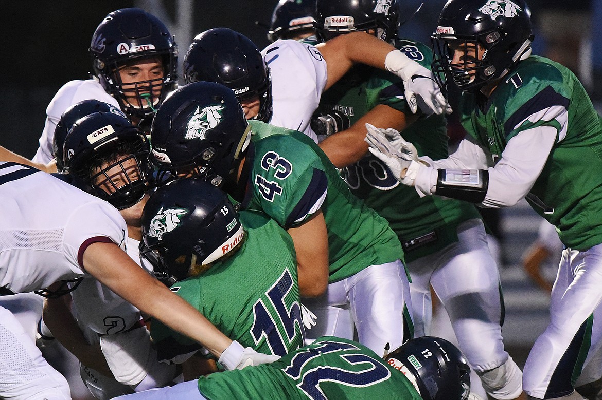 The Glacier defense swarms Mount Spokane running back Tommy Madill (2) at Legends Stadium on Friday. (Casey Kreider/Daily Inter Lake)