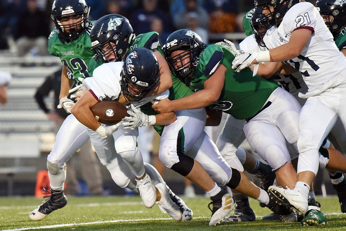 Glacier defenders Henry Nuce (57) and Justin Olson (53) force a fumble from Mount Spokane running back Connor Marll (3) in the second quarter at Legends Stadium on Friday. (Casey Kreider/Daily Inter Lake)