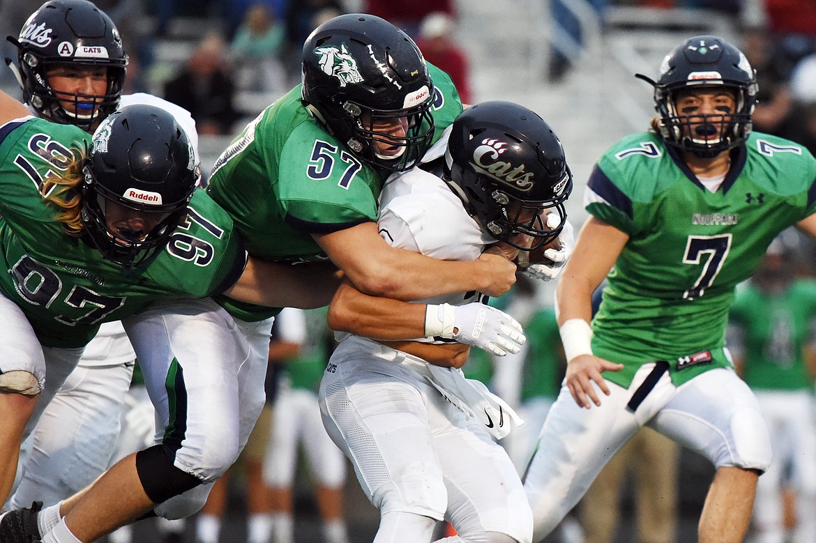 Glacier's Thomas Cole (97), Henry Nuce (57) and Ben Stotts (7) tackle Mount Spokane running back Connor Marll (3) in the first half at Legends Stadium on Friday. (Casey Kreider/Daily Inter Lake)