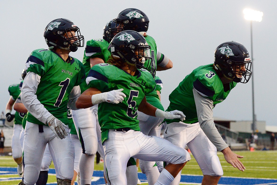 Glacier's Colin Bowden (1), Drew Deck (5) and JT Allen (3) celebrate with teammates after Allen's touchdown pass to Deck in the second quarter against Mount Spokane at Legends Stadium on Friday. (Casey Kreider/Daily Inter Lake)