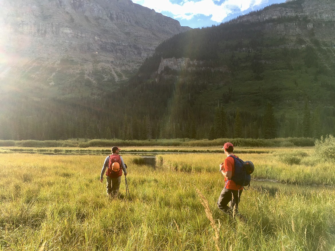 Rick Laverty and Danny McKay enjoy the morning sun in the Mirror Pond area of the Gunsight Lake Trail while en route to climb Mount Jackson on Sept. 1 in Glacier National Park. (Matt Baldwin/Daily Inter Lake)