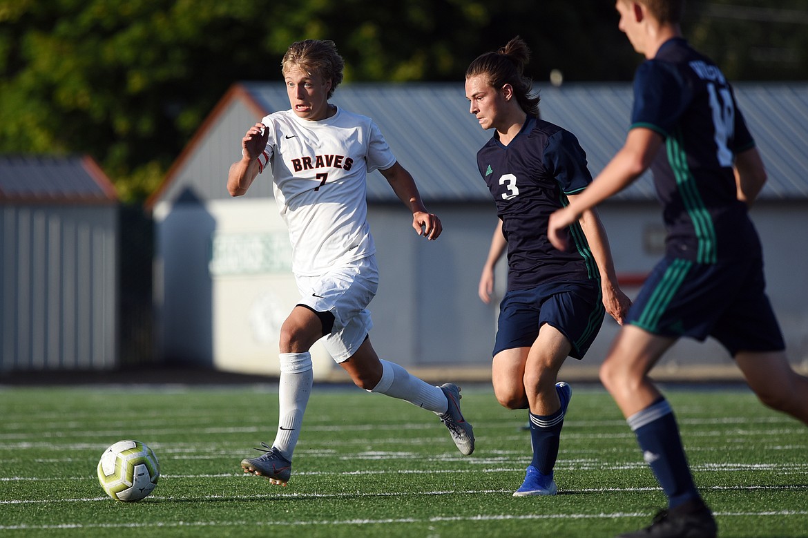 Flathead's Jalen Hawes (7) pushes the ball upfield with Glacier's Blake Marlow (3) in pursuit during crosstown soccer at Legends Stadium on Thursday. (Casey Kreider/Daily Inter Lake)