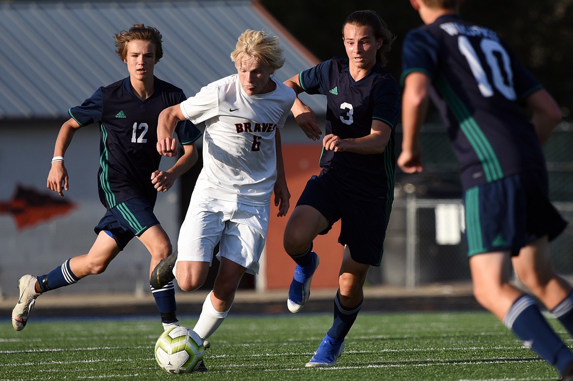 Flathead's Eric Gardner (6) pushes the ball upfield with Glacier's Campbell Smith (12) and Blake Marlow (3) defending during crosstown soccer at Legends Stadium on Thursday. (Casey Kreider/Daily Inter Lake)