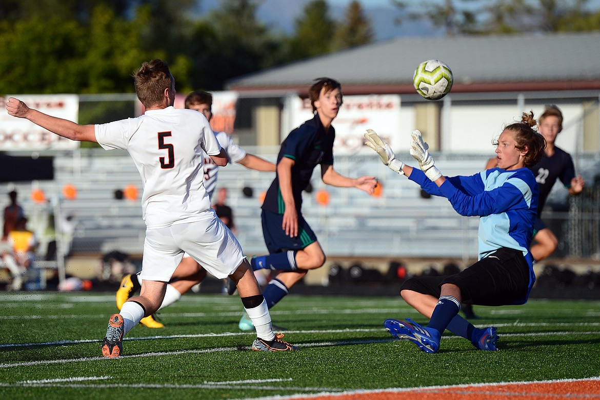 Glacier goalkeeper John Pyron (1) forces a shot by Flathead's AJ Apple (5) wide of the net during crosstown soccer at Legends Stadium on Thursday. (Casey Kreider/Daily Inter Lake)