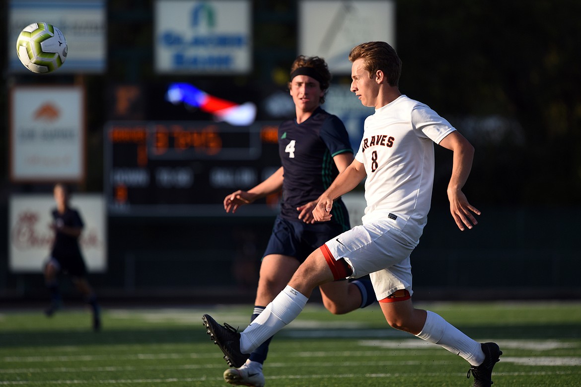 Flathead's Kell Rasnic (8) flips the ball out of the Braves' zone with Glacier's Braden Nitschelm (4) in pursuit during crosstown soccer at Legends Stadium on Thursday. (Casey Kreider/Daily Inter Lake)