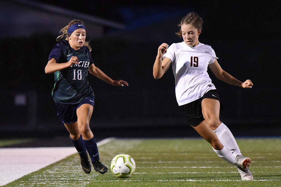 Glacier's Madison Becker (18) and Flathead's Bridget Crowley (19) chase down a ball during crosstown soccer at Legends Stadium on Thursday. (Casey Kreider/Daily Inter Lake)