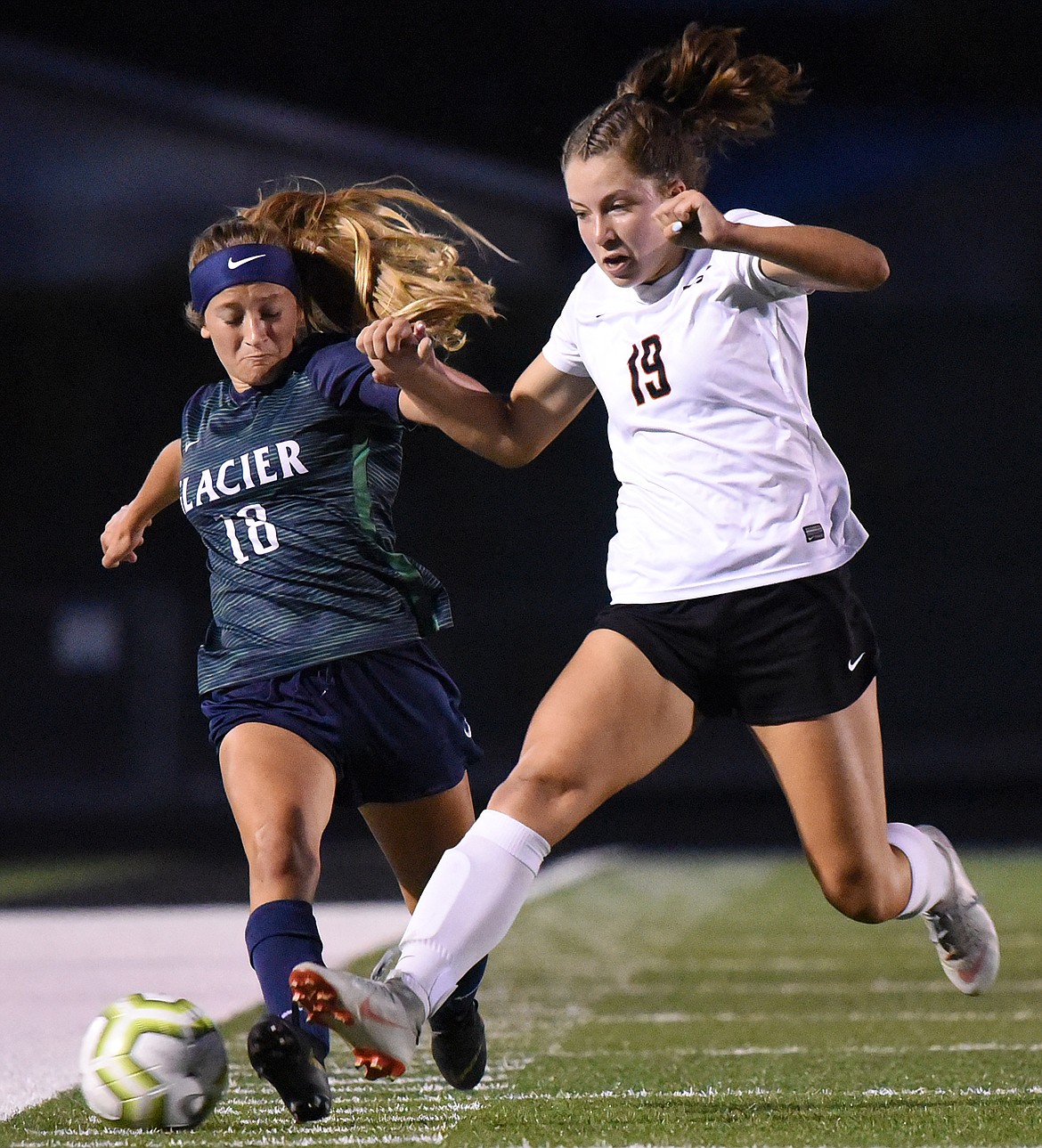 Glacier's Madison Becker (18) and Flathead's Bridget Crowley (19) battle for a ball in the first half during crosstown soccer at Legends Stadium on Thursday. (Casey Kreider/Daily Inter Lake)