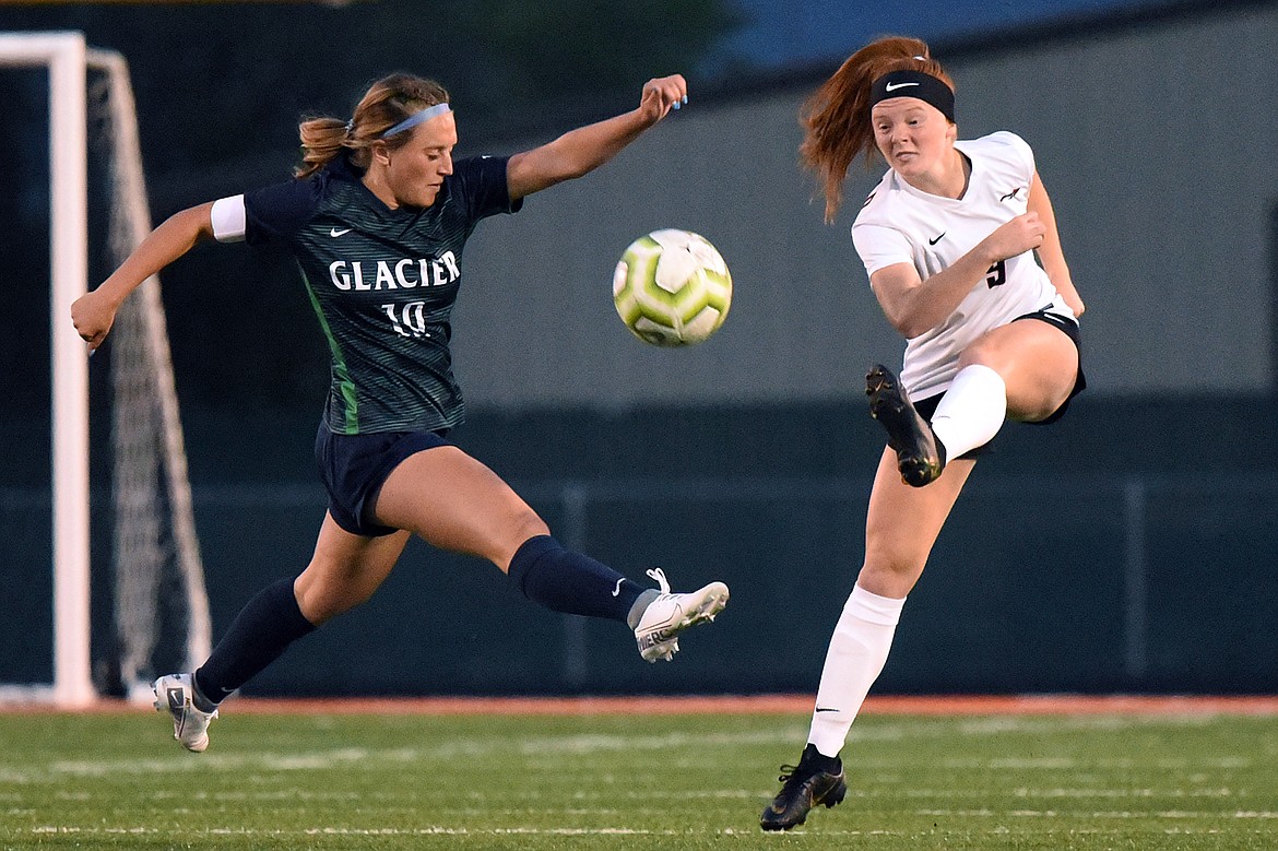 Flathead's Skyleigh Thompson (9) passes the ball upfield with Glacier's Micah Hicketheir (10) defending during crosstown soccer at Legends Stadium on Thursday. (Casey Kreider/Daily Inter Lake)