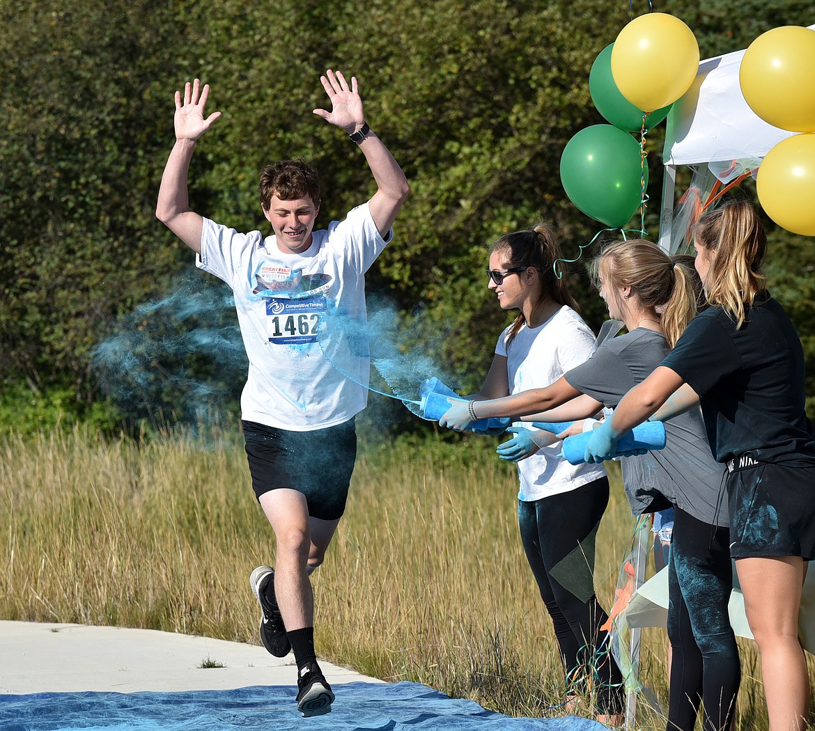 Paul Harms gets splashed with blue Saturday morning during the Great Fish Community Challenge Color Run through Whitefish. (Heidi Desch/Whitefish Pilot)