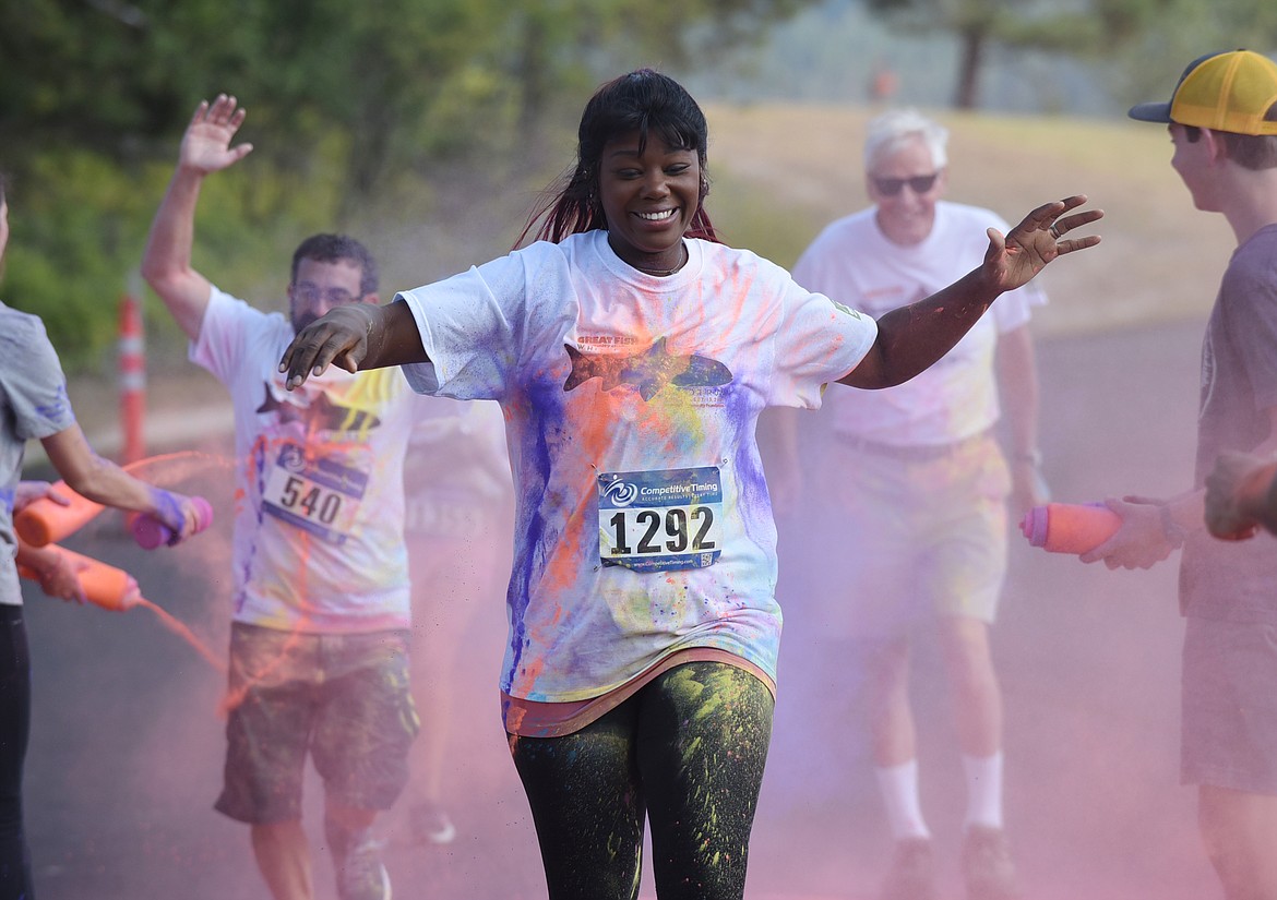 Jeanetta Grilley gets splashed with orange and purple colors Saturday morning during the Great Fish Community Challenge Color Run through Whitefish. (Heidi Desch/Whitefish Pilot)