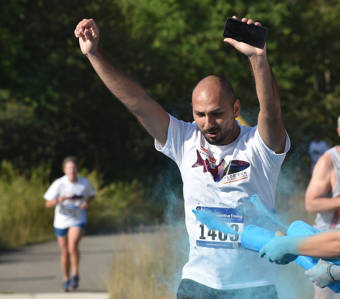 Percival Field gets splashed with blue Saturday morning during the Great Fish Community Challenge Color Run through Whitefish. (Heidi Desch/Whitefish Pilot)