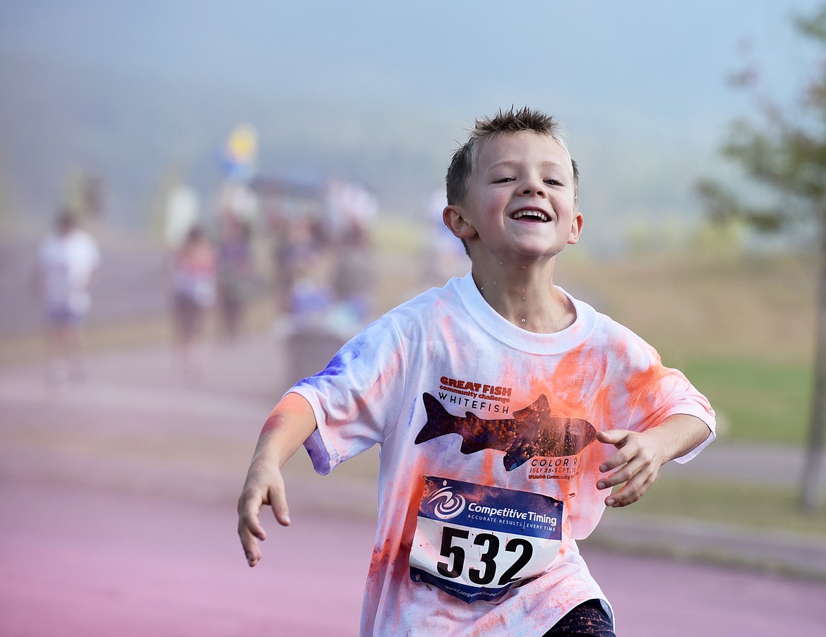 Brody Peltier, 7, is all smiles after passing through a color station Saturday morning during the Great Fish Community Challenge Color Run through Whitefish. (Heidi Desch/Whitefish Pilot)