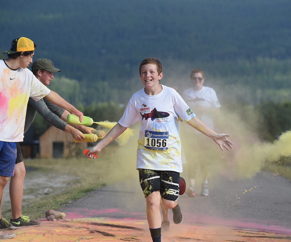 Connor Keith, 12, runs through the green and yellow station Saturday morning during the Great Fish Community Challenge Color Run through Whitefish. (Heidi Desch/Whitefish Pilot)