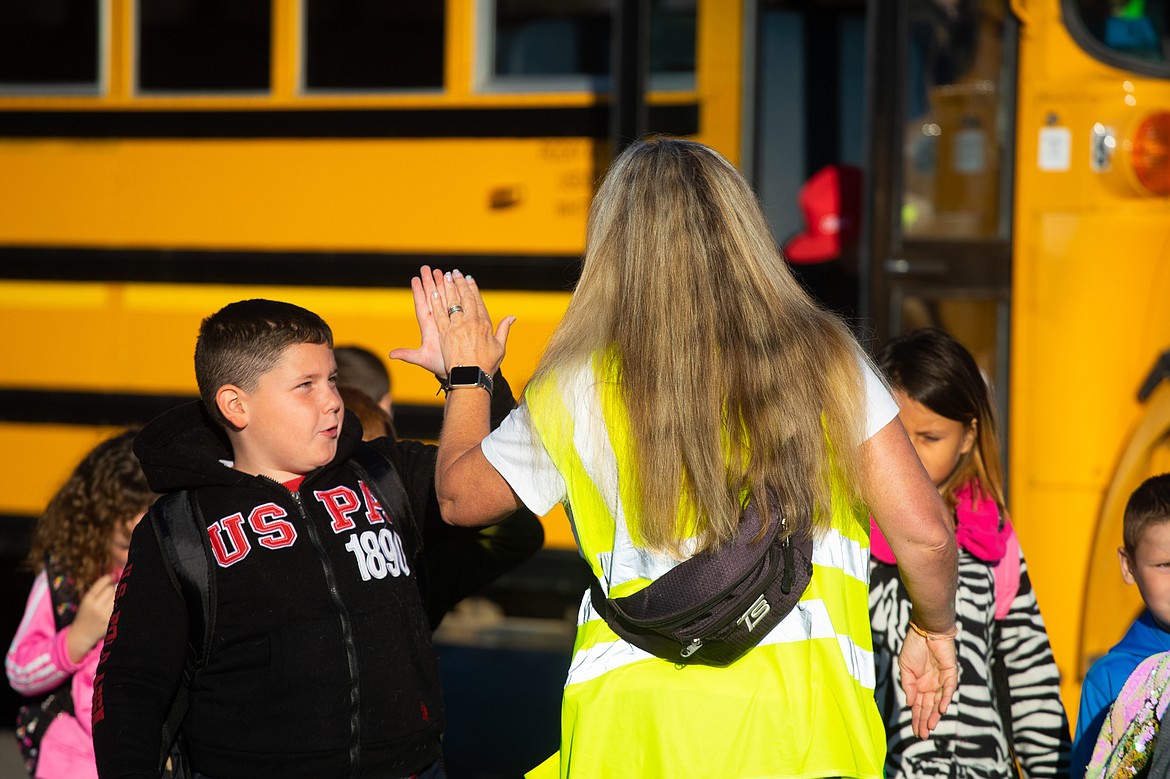 Jesse Livingston student high fives Eden Dias as he comes off the bus on the first day of school. (Daniel McKay/Whitefish Pilot)