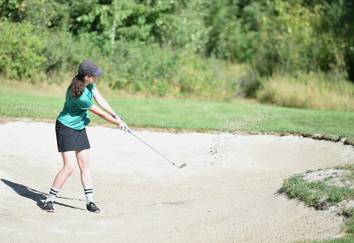 Ella Shaw chips a shot out of the bunker last week at Whitefish Lake Golf Club. (Daniel McKay/Whitefish Pilot)