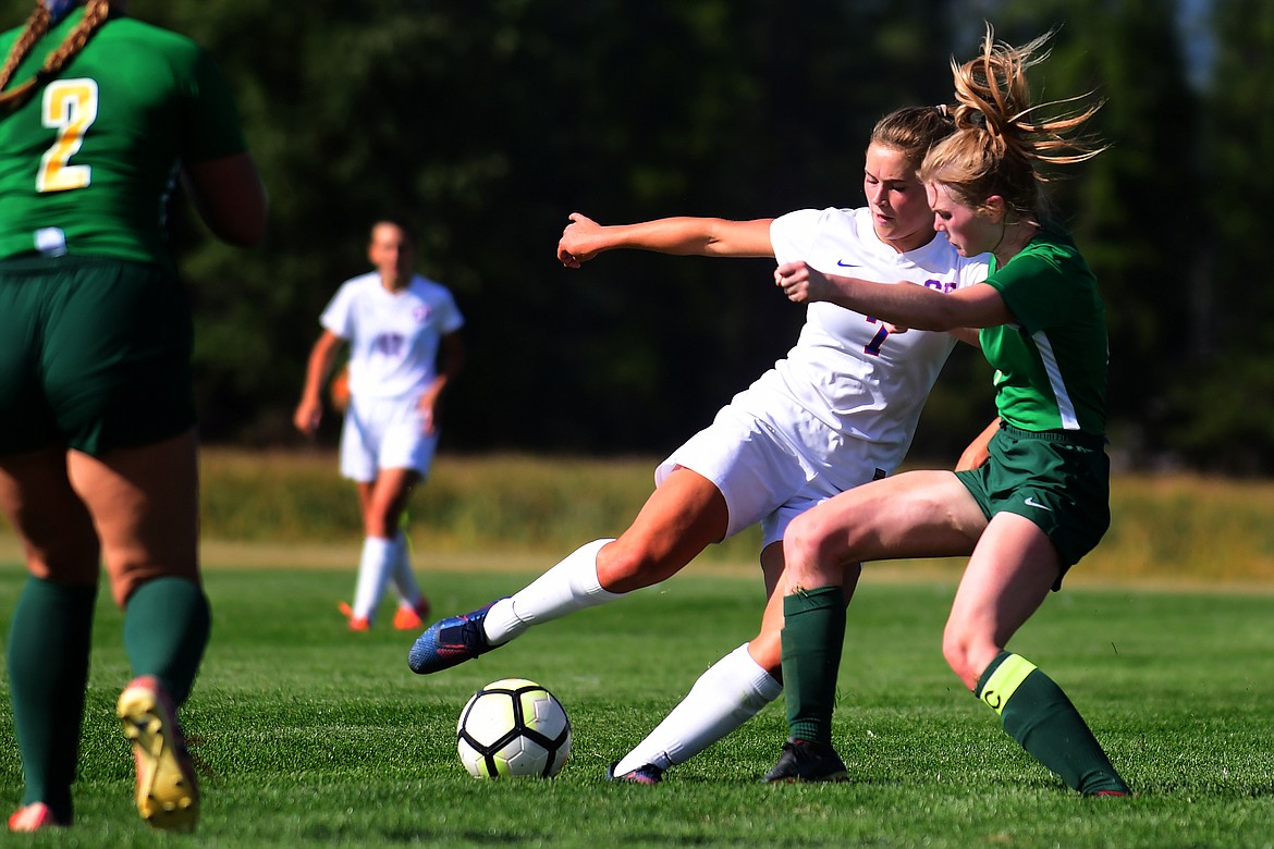 Wildkat Maddie Robison kicks the ball past Whitefish defender Mary Peterson.