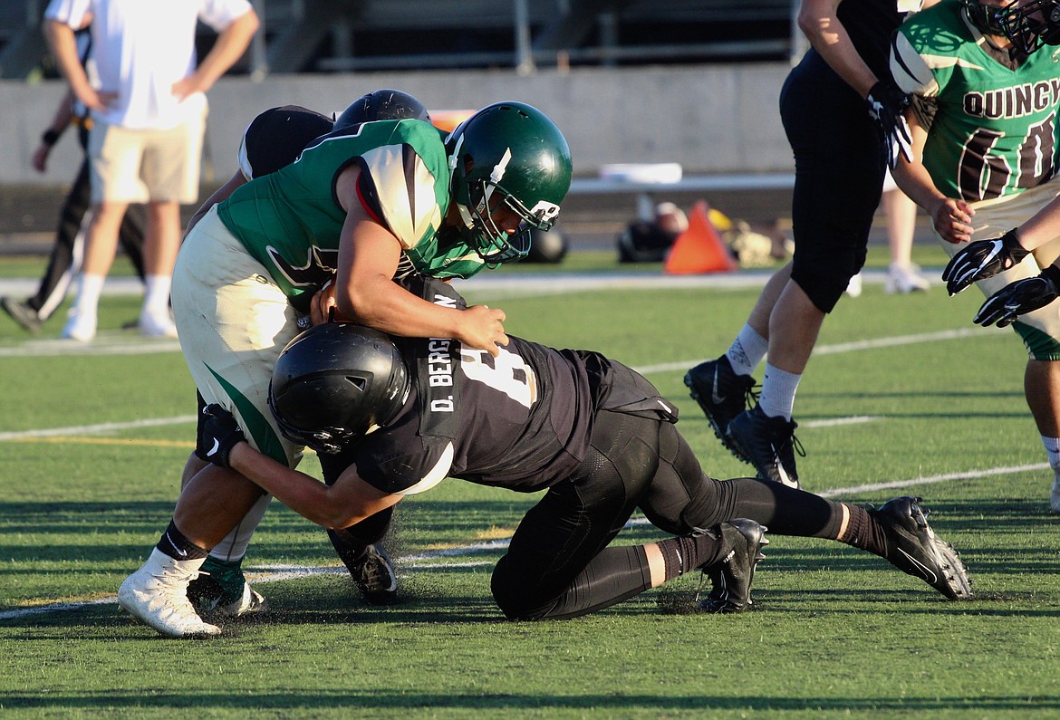 Casey McCarthy/Sun Tribune
Derek Bergeson and another Royal High School defensive player make the tackle against Quincy at Royal High School on Friday, Aug.30.