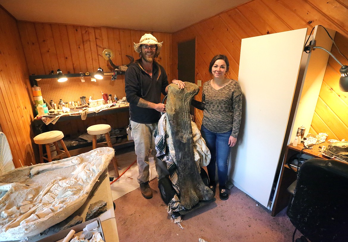 NorthWest Montana Fossils owners Aamon Jaeger and Chantel Ibach display a 54-inch long Sauropod femur from the Morrison Formation. It is estimated to be 155 million years old. (Mackenzie Reiss/Daily Inter Lake)